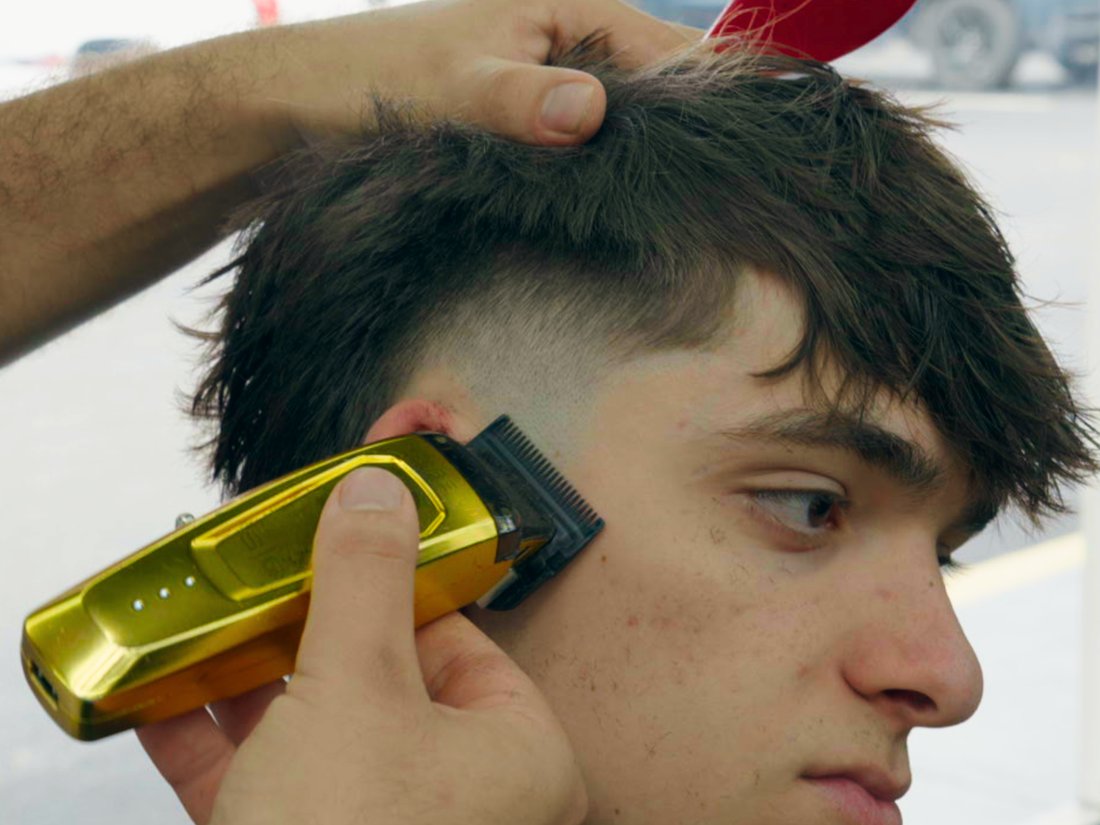 A fresh fade in progress with the gold clippers at SH Barbershop